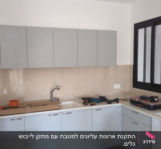 מטבח עם ארונות אפורים, כלים על השיש